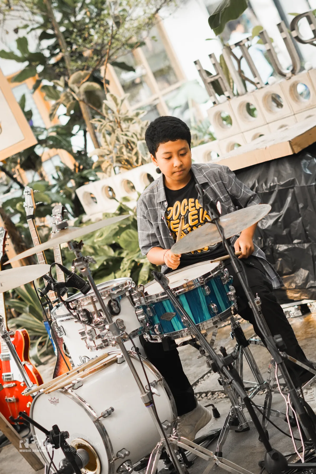 Murid laki-laki bermain drum di Annual Home Concert 2026